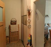 In der 2-Zimmer-Wohnung gibt es eine Holzeinrichtung, einen Korb, Dekorationen und einen Blick auf die Küche.