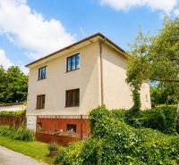 Ein Einfamilienhaus in der Straße Pod Laščeky in Žilina, umgeben von grüner Vegetation.