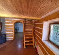 Holztreppe, Herd und Steinverkleidung in einem Einfamilienhaus mit Holzbodenoptik.