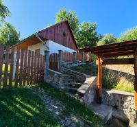 Ein Einfamilienhaus in Mikušovce mit einem Holzzaun und einer Steintreppe.