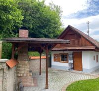 Ein Einfamilienhaus in Mikušovce mit einem Gartenunterstand und einem Ziegelkamin.
