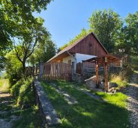 Ein Familienhaus in Mikušovce, umgeben von Grünflächen, mit einem Weg, der zu einem hölzernen Tor führt.