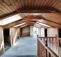 Das Dachgeschoss eines Einfamilienhauses mit Holzverkleidung und Dachfenstern.