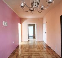 Innenraum eines Einfamilienhauses mit Kronleuchter, rosa Wand und Fliesenboden.