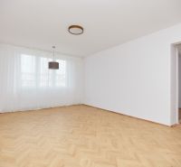 Helles Zimmer in einer 3-Zimmer-Wohnung mit Holzboden und weißen Vorhängen.