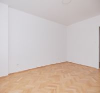 Ein Raum mit hellen Wänden und einem Boden in Holzoptik in einer 3-Zimmer-Wohnung.