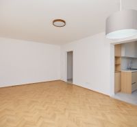Wohnzimmer in einer 3-Zimmer-Wohnung mit Holzboden und Zugang zur Küche.