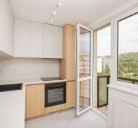Küche in einer 3-Zimmer-Wohnung mit Blick vom Balkon und einem Boden mit Holzdekor.