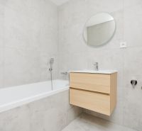 Badezimmer in einer 3-Zimmer-Wohnung mit Badewanne und hellen Fliesen.