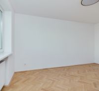 Ein leerer Raum mit Holzboden in einer 3-Zimmer-Wohnung.