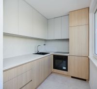 Eine Küchenzeile in einer 3-Zimmer-Wohnung mit Holzelementen und hellen Schränken.