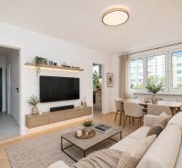 Wohnzimmer in einer 3-Zimmer-Wohnung mit Holzboden und hellen Möbeln.