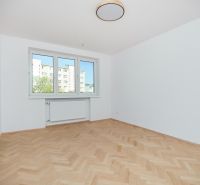 Ein Zimmer in einer 3-Zimmer-Wohnung mit weißen Wänden und einem Boden in Holzoptik.