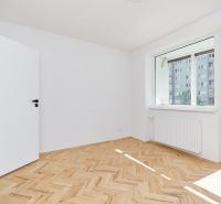 Ein Zimmer in einer 3-Zimmer-Wohnung mit einem Boden in Holzoptik und einem großen Fenster.