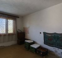 Ein Zimmer in einem Einfamilienhaus mit einem großen Fenster, einem Vorhang und minimalistischer Einrichtung.
