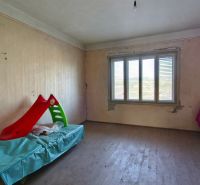 Ein Zimmer mit einem Holzboden und Spielzeug in einem Einfamilienhaus.