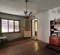 Ein Zimmer in einem Einfamilienhaus mit einfacher Einrichtung und einer Lampe an der Decke.