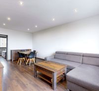 Wohnzimmer mit Sofa, Esstisch und Holzboden in einer 4-Zimmer-Wohnung.