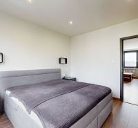 Helles Schlafzimmer mit Bett und Holzboden in einer 4-Zimmer-Wohnung.