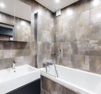 Badezimmer mit modernen Fliesen und Sanitäranlagen in einer 4-Zimmer-Wohnung.