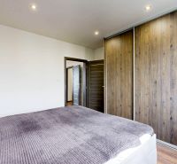 Schlafzimmer in einer 4-Zimmer-Wohnung mit einem Schiebeschrank und einem Boden in Holzoptik.