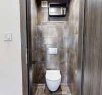Toilette mit dunklen Fliesen in einer 4-Zimmer-Wohnung, elegantes Raumdesign.