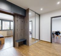 Eingangsbereich einer 4-Zimmer-Wohnung mit Holzboden, Einbauschrank und Kleiderhaken.