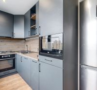 Küche in einer 4-Zimmer-Wohnung mit moderner Ausstattung und Bodenbelag in Holzoptik.
