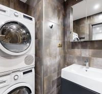 Badezimmer mit Waschmaschine, Trockner und Waschbecken in einer 4-Zimmer-Wohnung.
