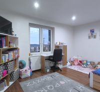 Kinderzimmer mit Bett, Schreibtisch, Regalen und einem Boden mit Holzdekor in einem Einfamilienhaus.