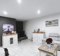 Wohnzimmer mit Holzboden, Sitzgarnitur und Dekorationen in einem Einfamilienhaus.