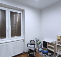 Kinderzimmer in einem Einfamilienhaus mit Spielzeug, Kinderwagen und Holzboden.