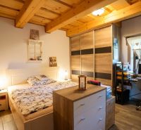 Ein Zimmer in einem Einfamilienhaus mit einem Bett, einem Schrank und einem Schreibtisch mit Computer.