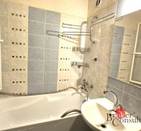 Badezimmer in einer 4-Zimmer-Wohnung mit Badewanne, Waschbecken und blauen Fliesen.