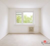 Ein helles Zimmer mit Bäumen vor dem Fenster, einem Heizkörper und einem Boden mit Holzdekor in einer 4-Zimmer-Wohnung.