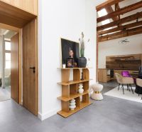 Innenraum einer 3-Zimmer-Wohnung mit Regal, eleganten Stühlen und Holzboden.