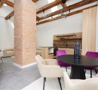 Ein stilvolles Wohnzimmer in einer 3-Zimmer-Wohnung mit einer Ziegelsäule und Holzbalken.