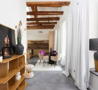 Wohnbereich einer 3-Zimmer-Wohnung mit Holzbalken und dekorativen Möbeln.