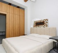 Schlafzimmer in einer 3-Zimmer-Wohnung mit Holzbalkendecke und geräumigem Bett.