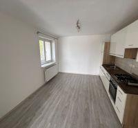 Küche mit weißer Küchenzeile in einer 3-Zimmer-Wohnung, Boden mit Holzdekor, großes Fenster.