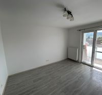 Ein Zimmer mit Holzboden und Balkon in einer 3-Zimmer-Wohnung.