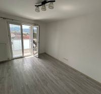Ein Zimmer in einer 3-Zimmer-Wohnung mit Holzboden und Balkon.