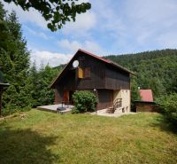 Das Haus in der Straße Rovné 61, Jaklovce, umgeben von Grün und Wald, mit einer Außensitzgelegenheit.