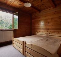 Holzinterieur mit Bett und Blick auf den Wald, Hütte.