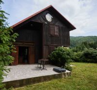 Das Haus auf Rovnom 61 in Jaklovce mit einer Holzfassade und einer Terrasse, umgeben von Grün.
