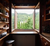 Küche in der Hütte mit Blick auf das Grün durch das offene Fenster.
