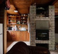 Das Innere der Hütte mit gemauertem Kamin, mit Holz verkleideten Schränken und Kochnische.