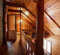 Hütte mit schräger Holzdecke, Boden mit Holzdekor und offenen Türen.