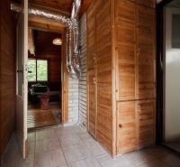 Innenraum einer Hütte mit Holzdekor und Lüftungsrohren bei den Schränken.