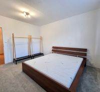 Schlafzimmer mit Bett und Kleiderständer in einer 2-Zimmer-Wohnung, Boden mit Holzdekor.